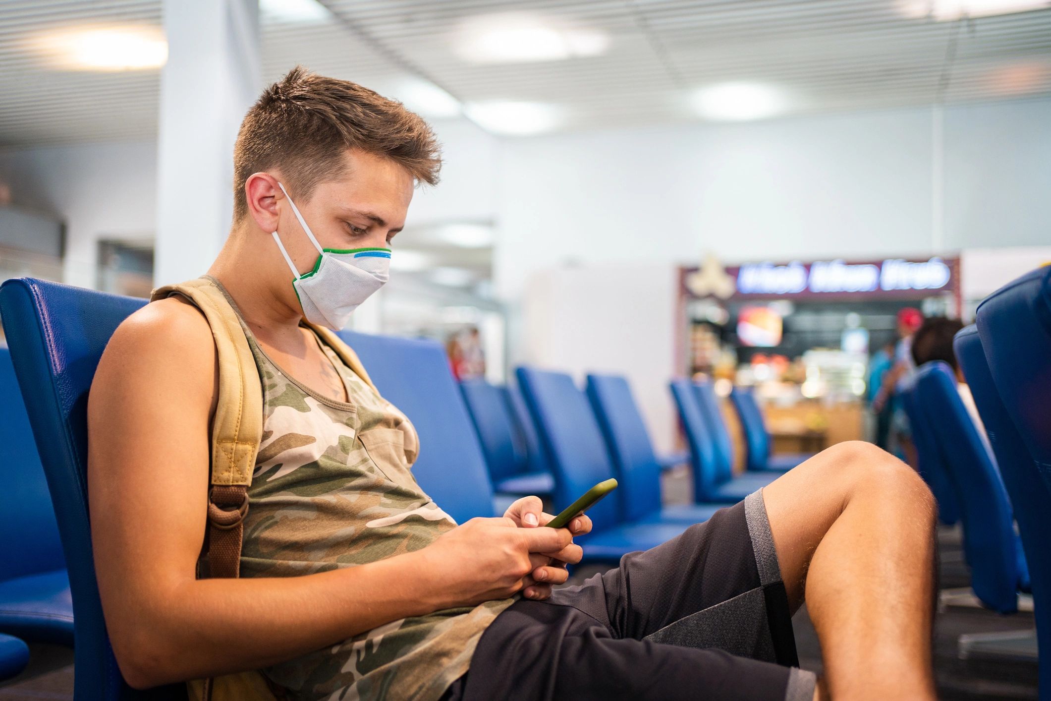 Traveler using phone while waiting at the airport